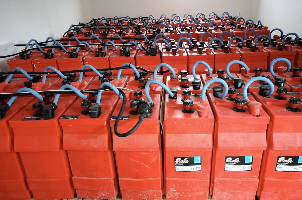 A battery backup sump pump system mounted beside a sump pit