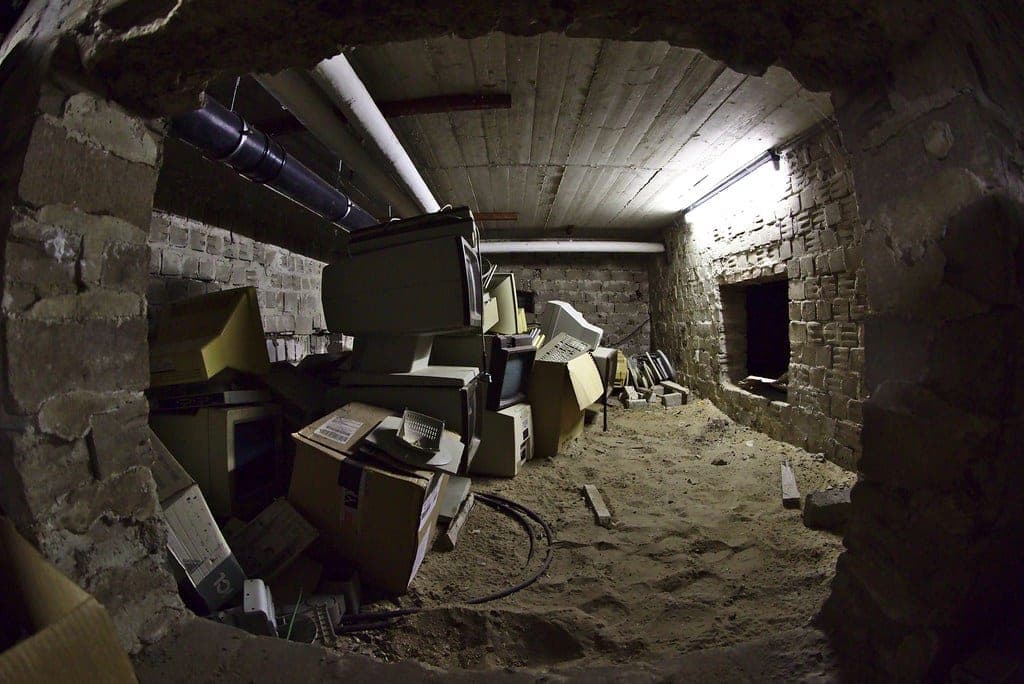 A crawl space with a plastic vapor barrier over bare ground
